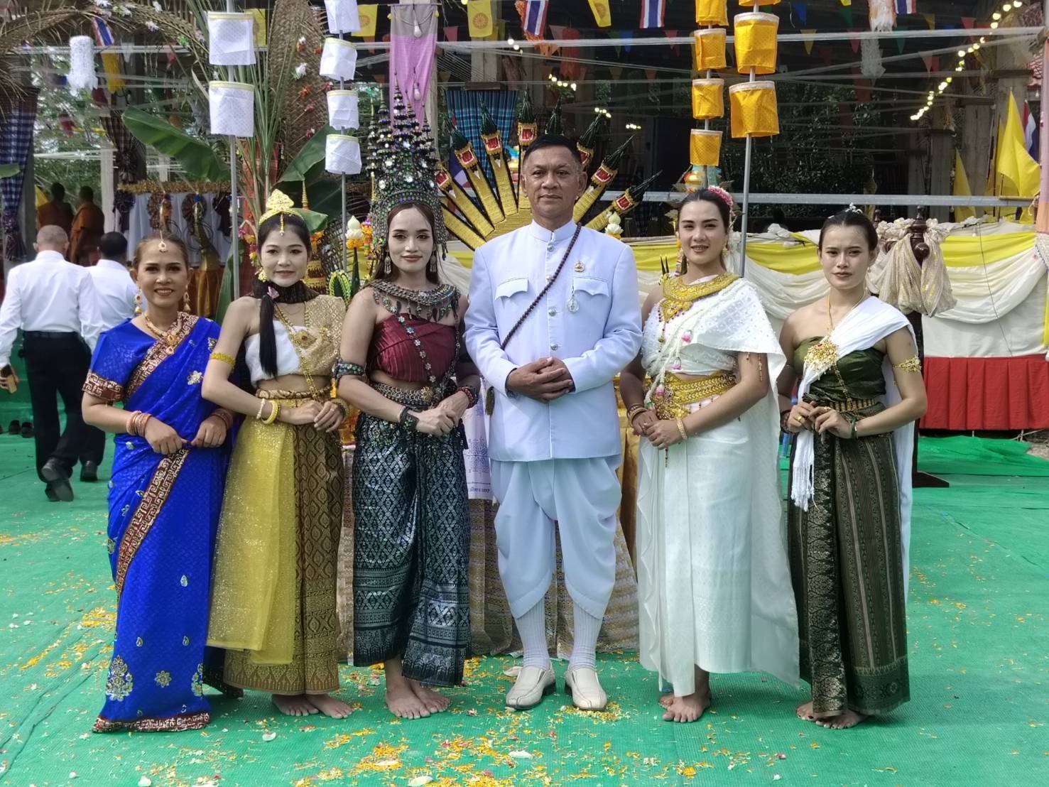 ชายไทยในชุดขาวและหญิงสาวในชุดไทยโบราณยืนถ่ายรูป